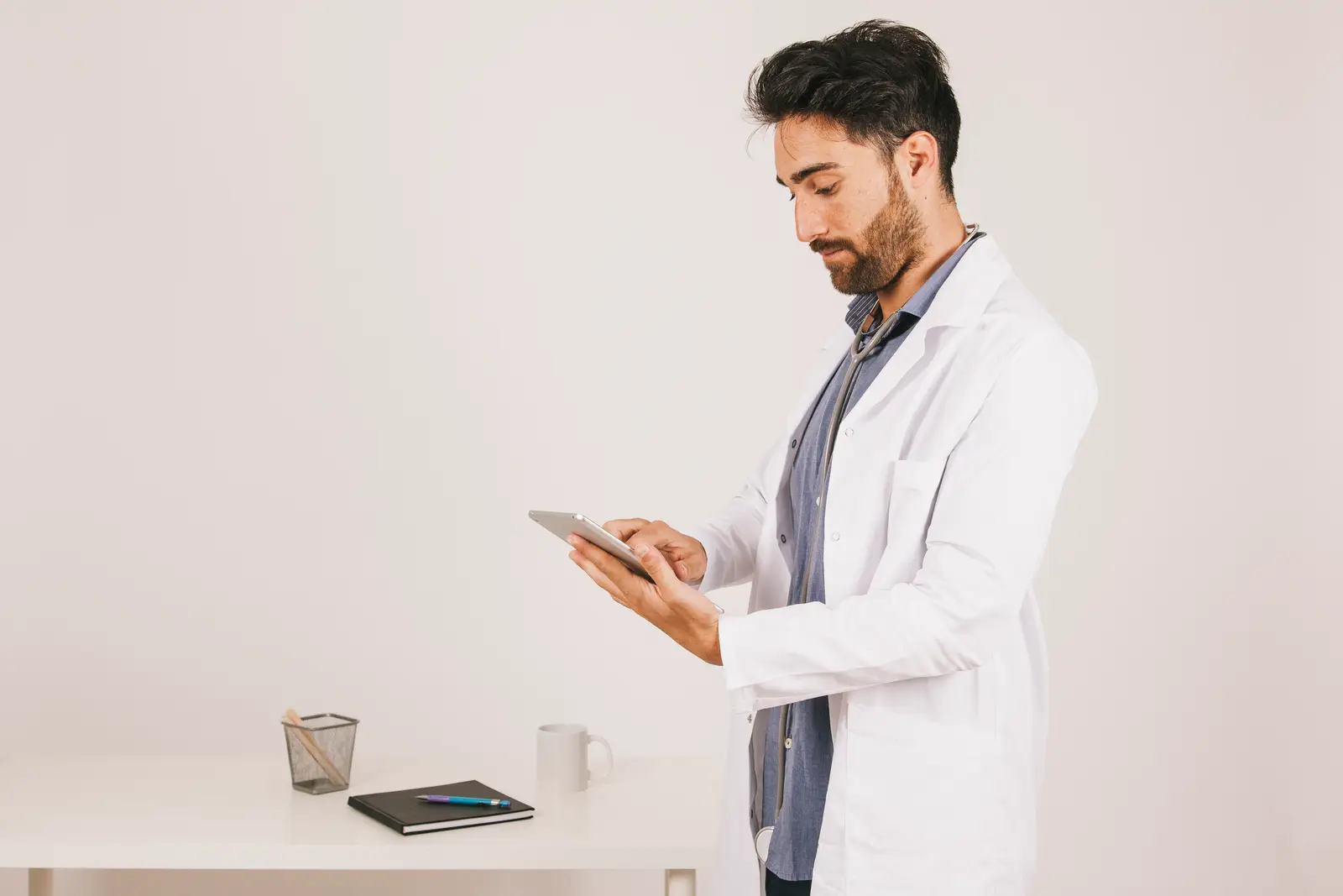 A doctor reviewing a patient's file on a tablet before the consultation